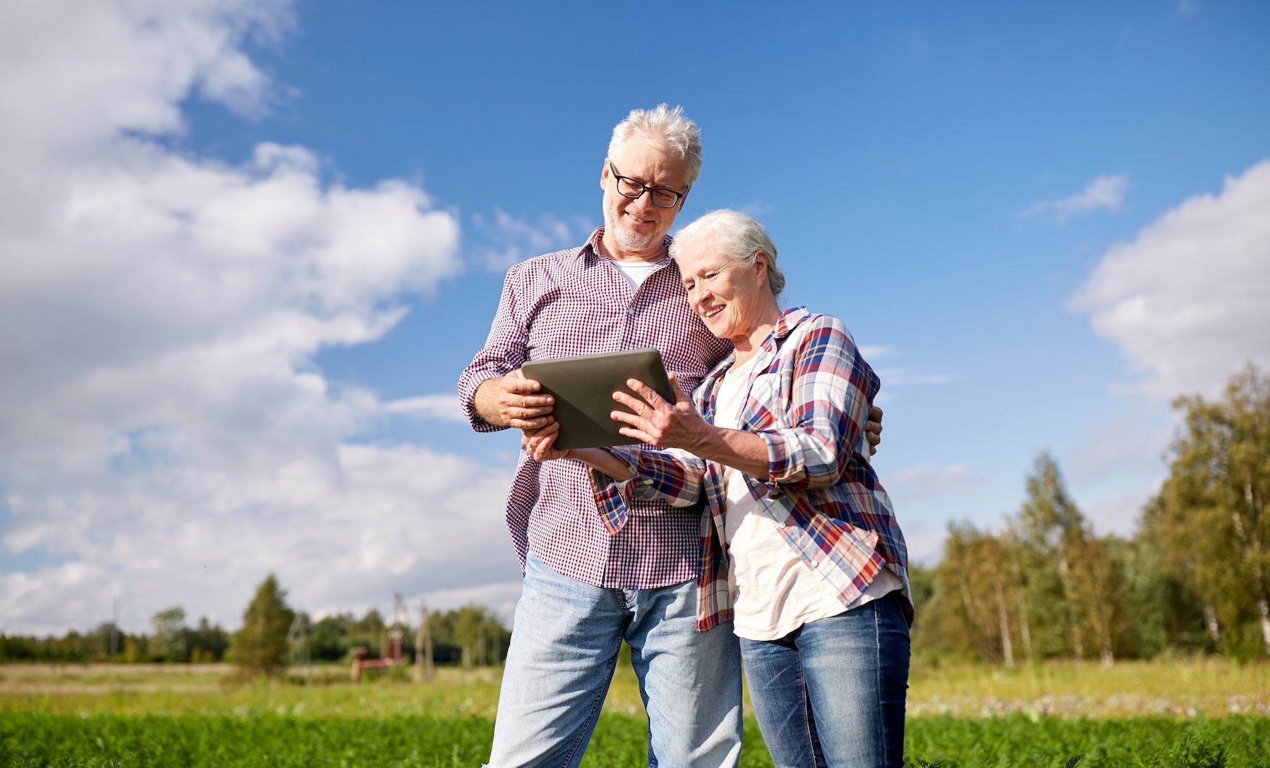 Senior couple looking at tablet together on their farm